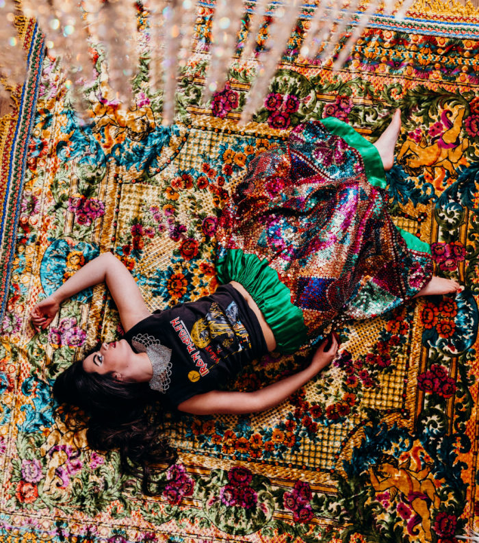 Katie sprawled out on an antique velvet rug modeling an 80s iron maiden tee from Charlie Dog and a China Poblana skirt from Malena's